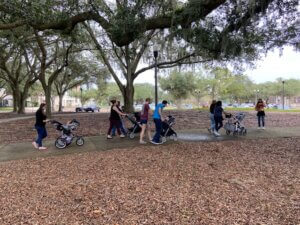 Parents walk through park during Baby and Me.